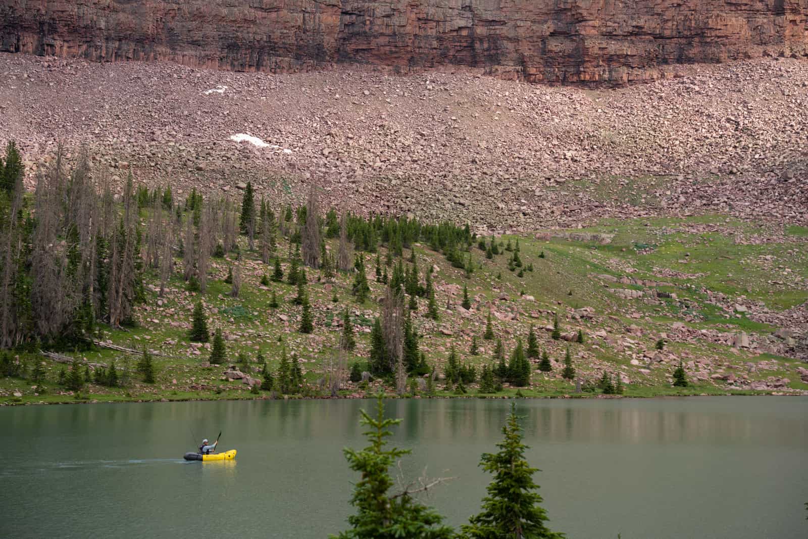 A small boat on a quiet lake seen from the shore