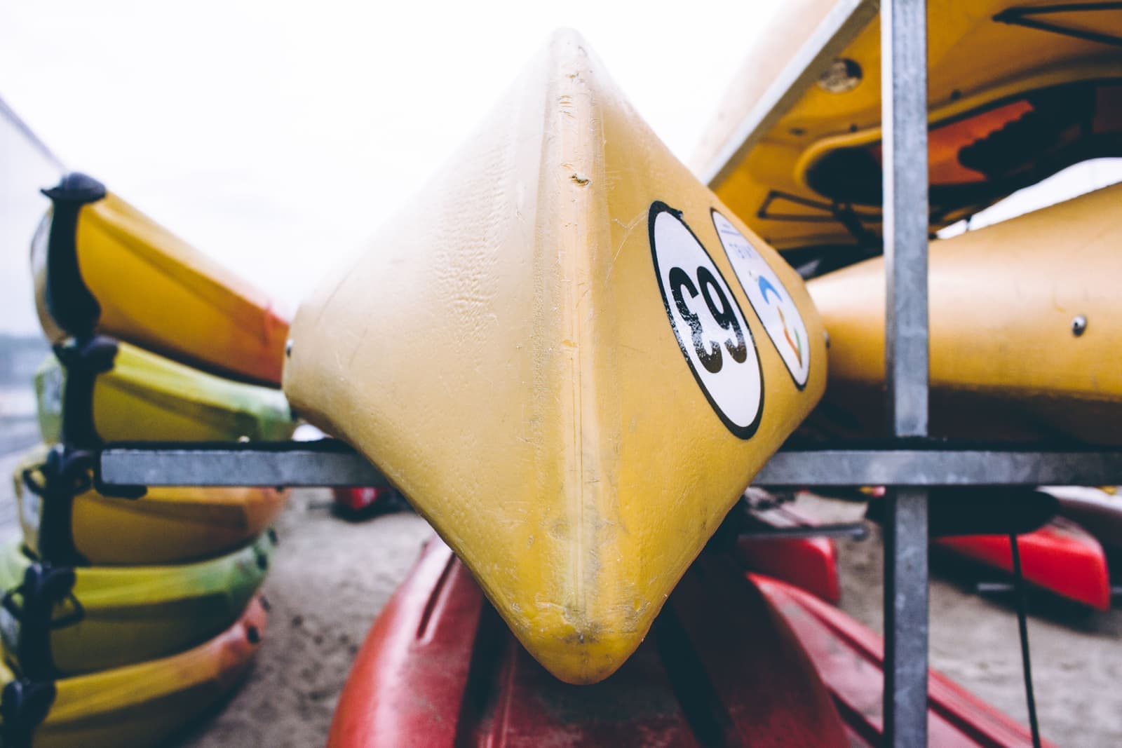A rigid kayak strapped to a metal roof rack