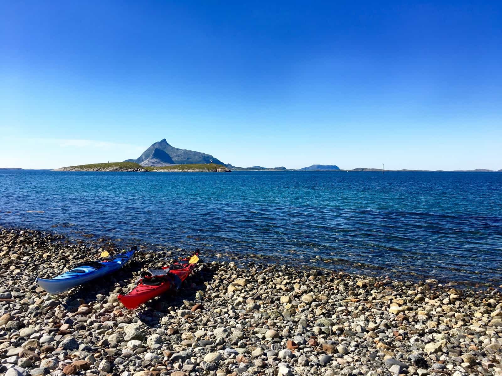 A kayak drawn up on a rocky lake shoreline
