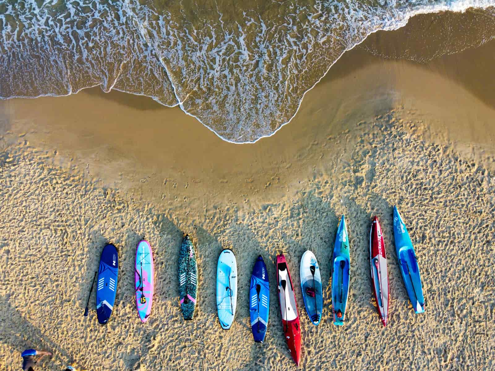 Boards and kayaks resting on a shoreline