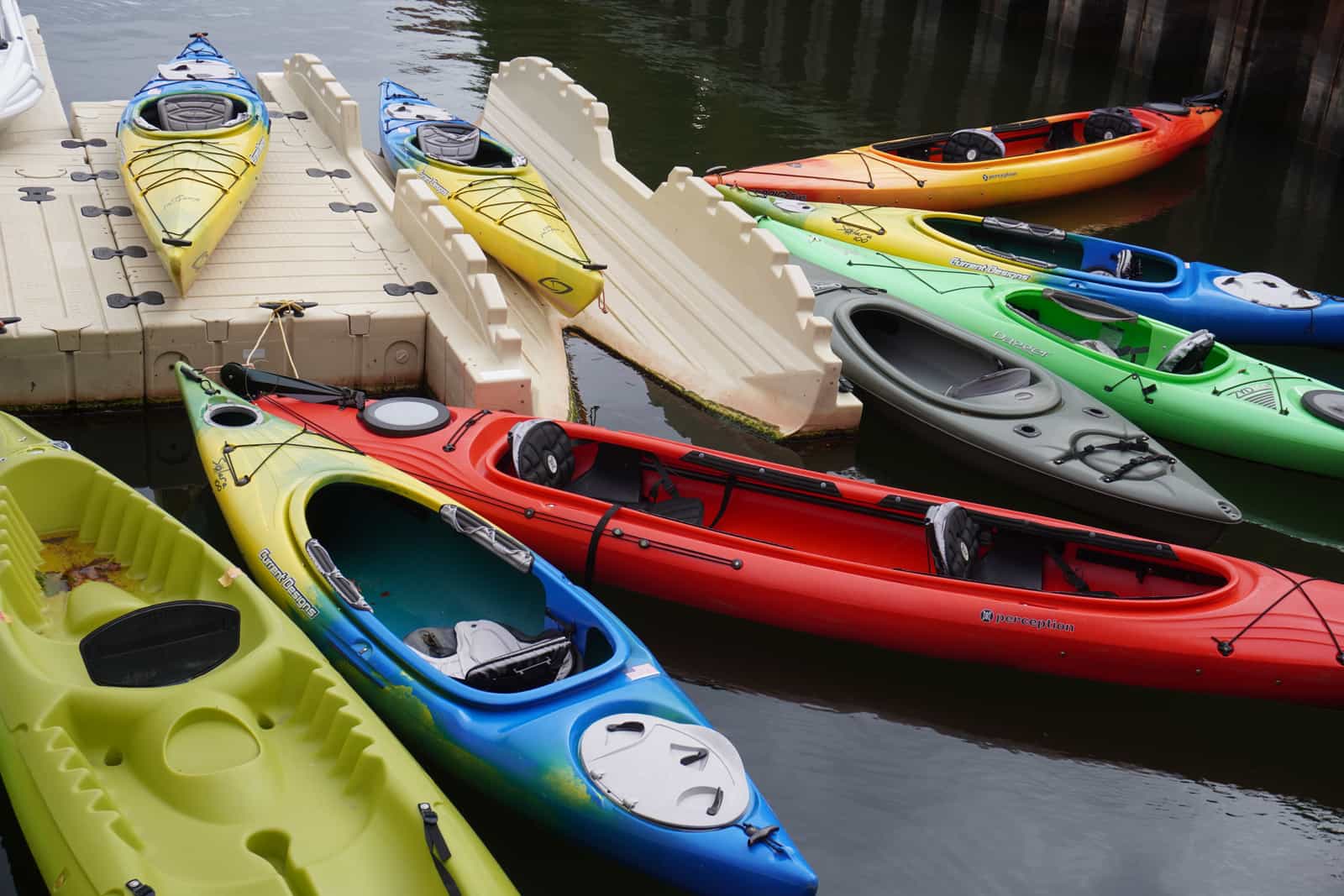 Colorful kayaks lined up along a waterfront dock
