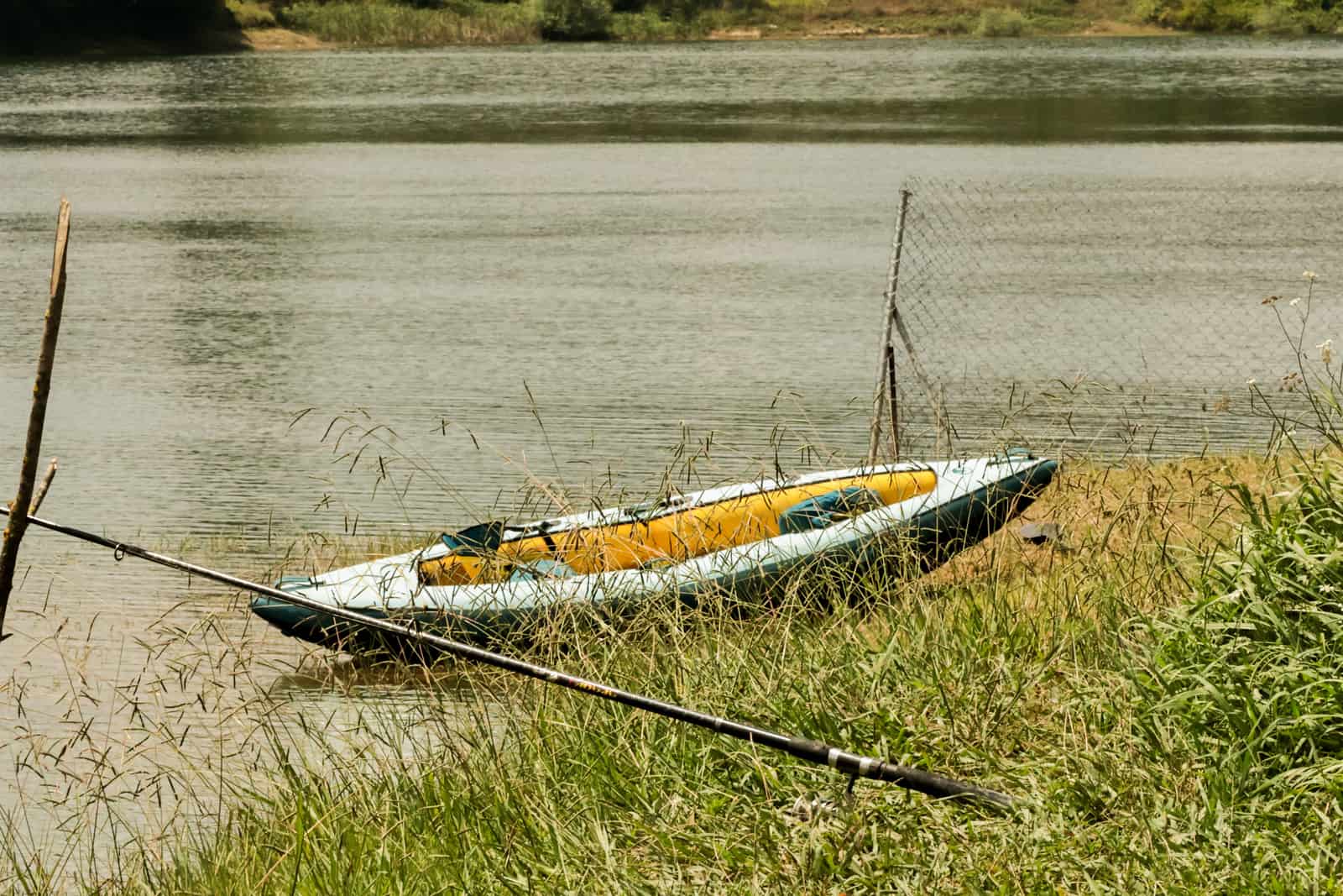 A kayak resting at the edge of a calm lake in summer