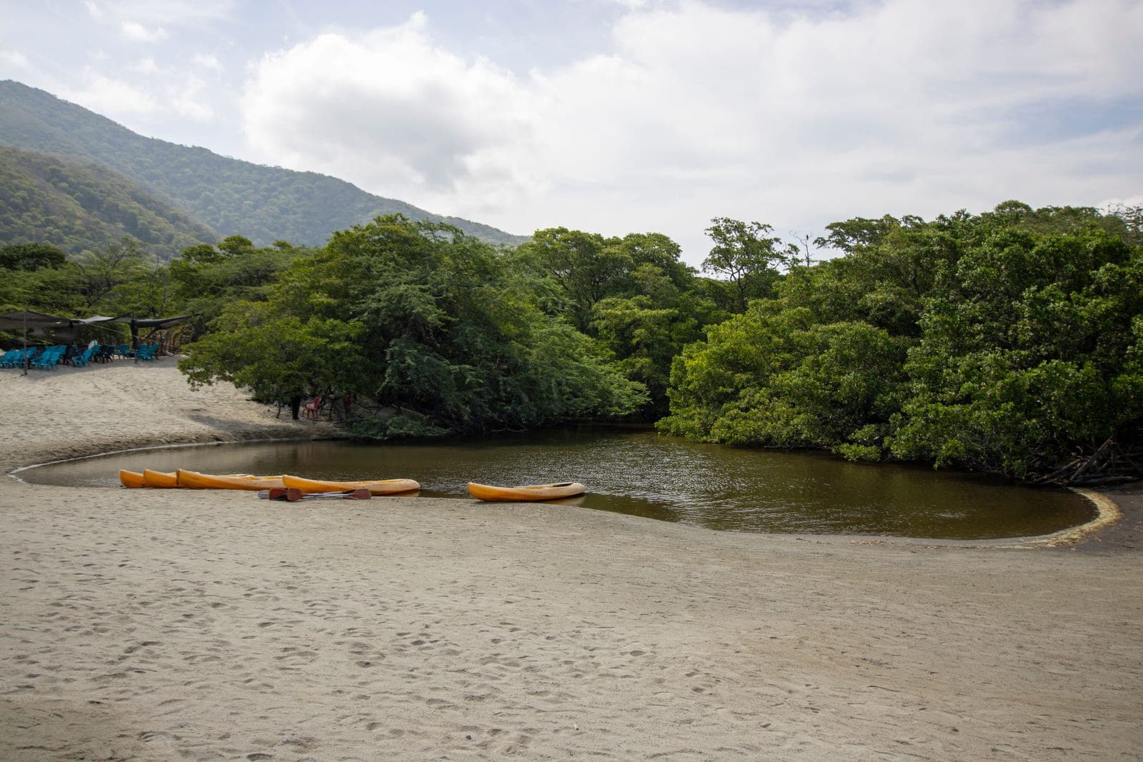 Kayaks pulled up on the sand at the edge of a lagoon
