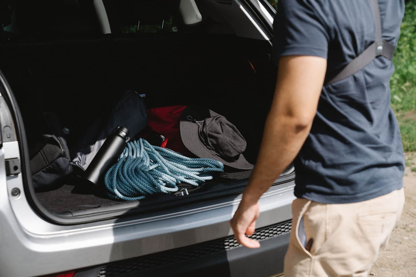 A compact packed kayak bag sitting in the open boot of a car