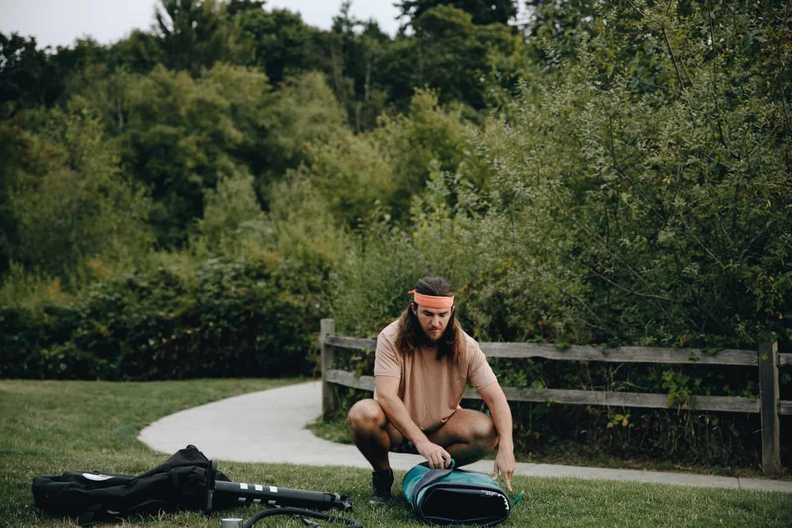 An electric pump inflating a stand up paddle board on grass