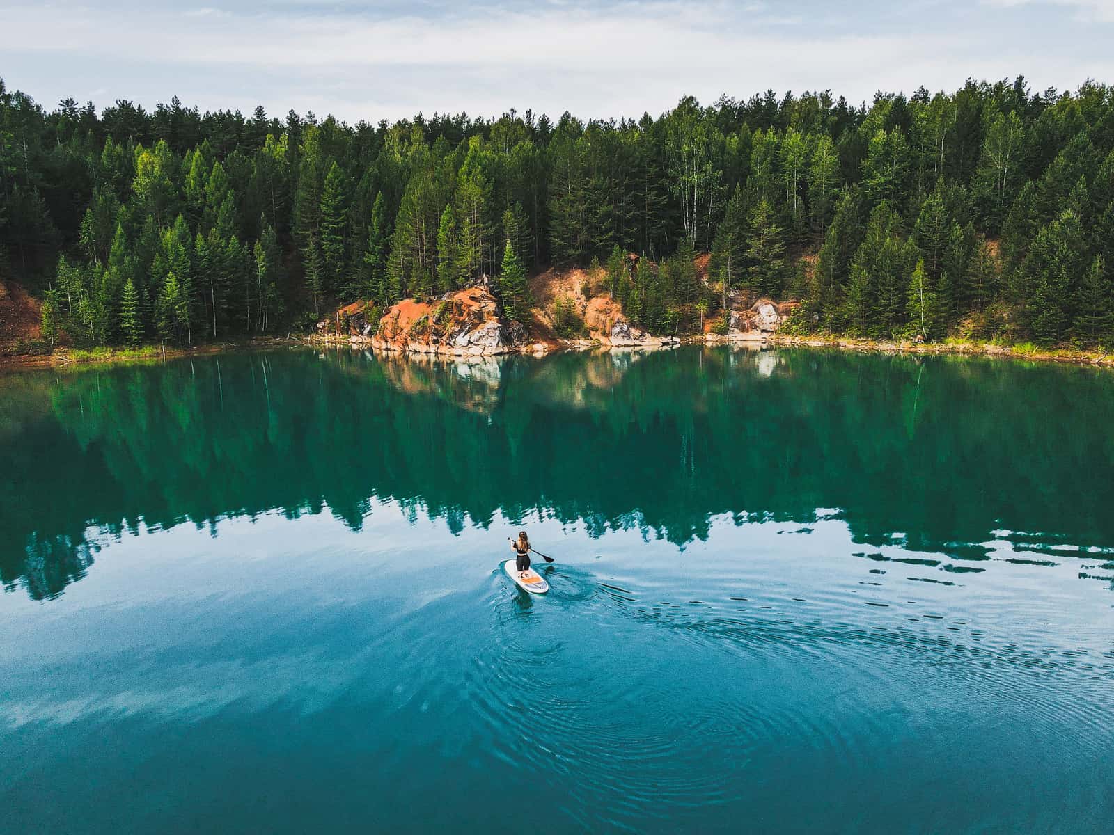 A paddler crossing a lake on a stand up paddle board