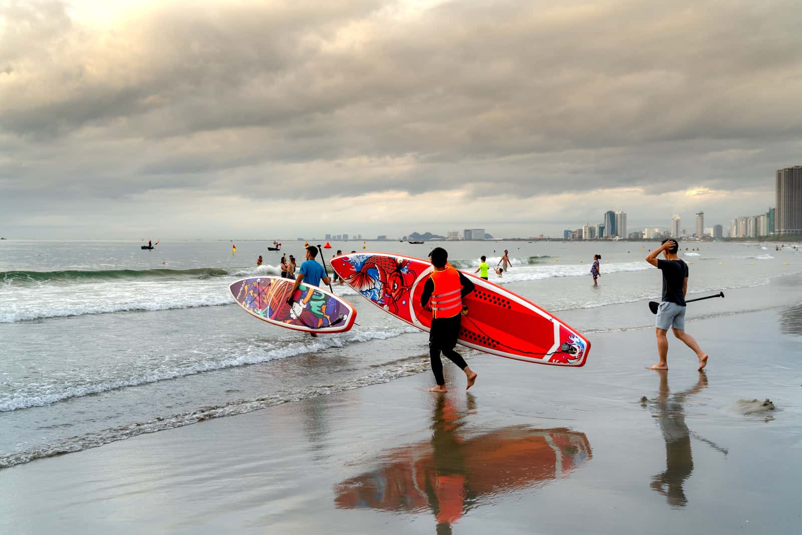 Paddle boards carried along a beach