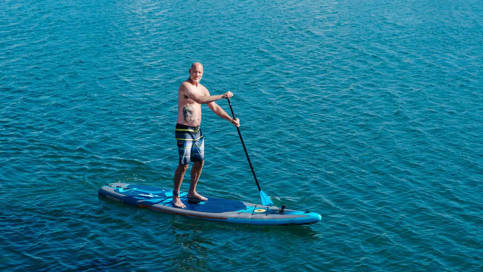 A paddler seated on a board on calm water